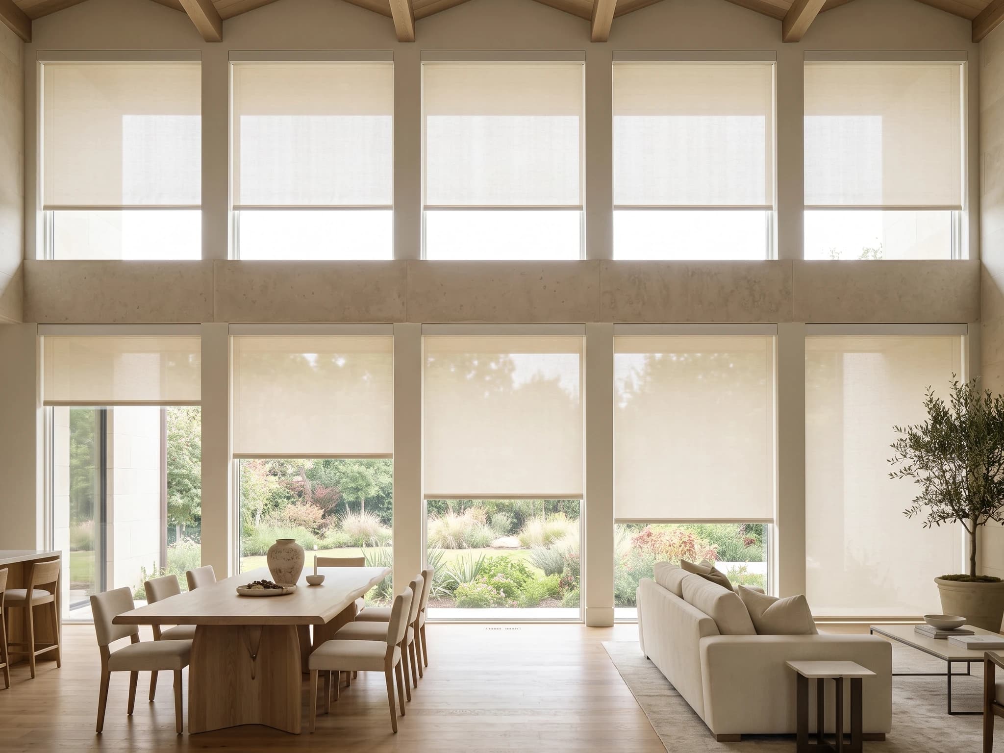 Approved light-filtering Roller Shades across both tiers of a double-height dining room