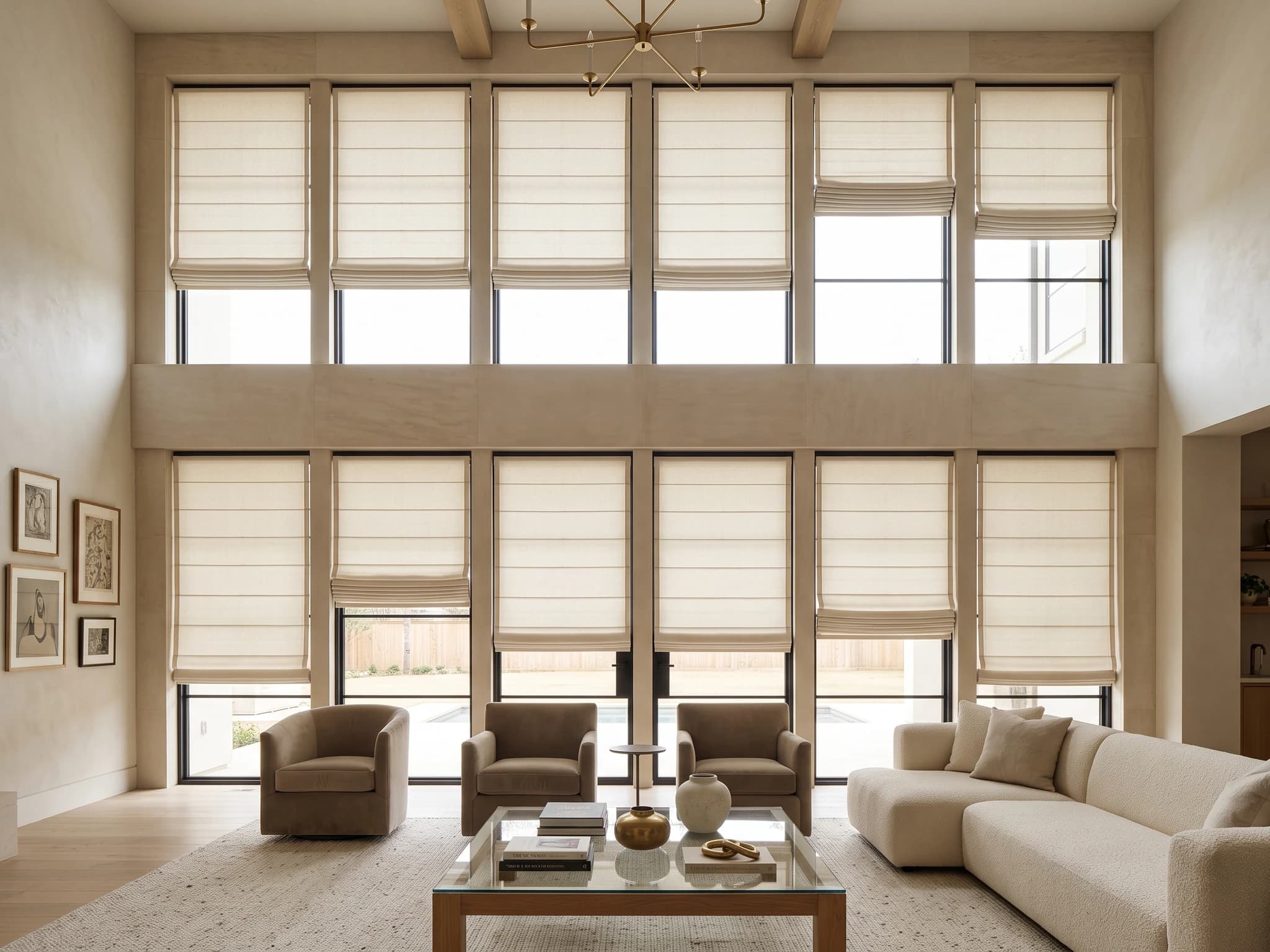 Flat Roman shades on upper and lower windows in a warm double-height living room